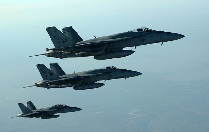 Three military fighter jets flying side by side